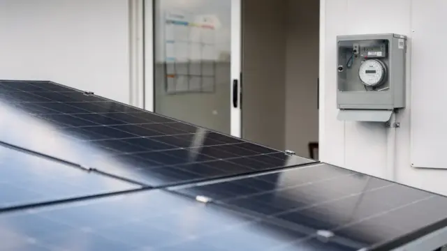 Solaranlage auf einem Hausdach mit Stromzähler und Kalender zum Thema Einspeisevergütung.